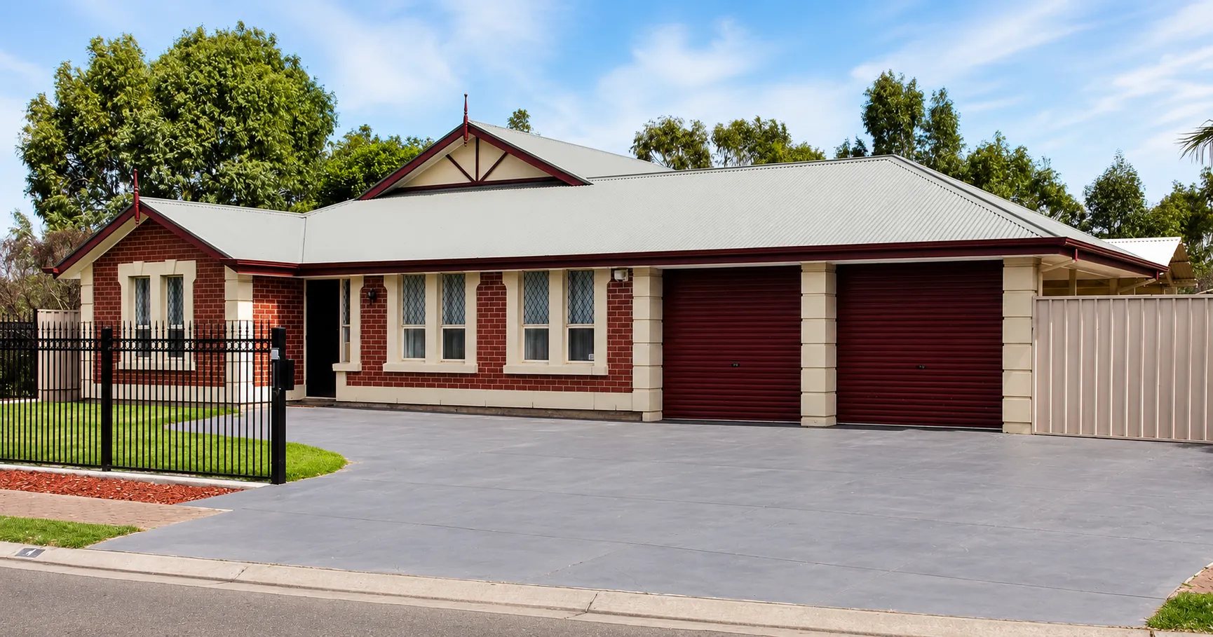 Driveway and double garage — sealed concrete, matching roller doors
